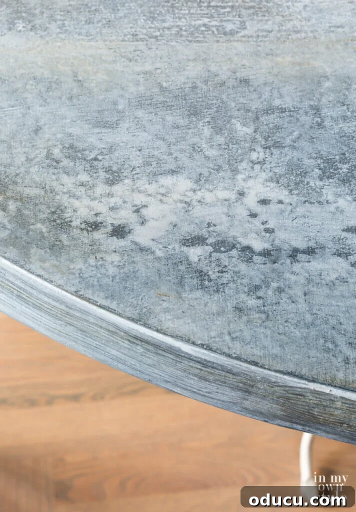 Zinc Effect Wooden Table Surfaces 21 The stunning final result of a faux zinc painted table top, displaying a realistic aged metal texture. The image highlights the detailed success of the DIY finish, perfect for rustic or industrial decor.