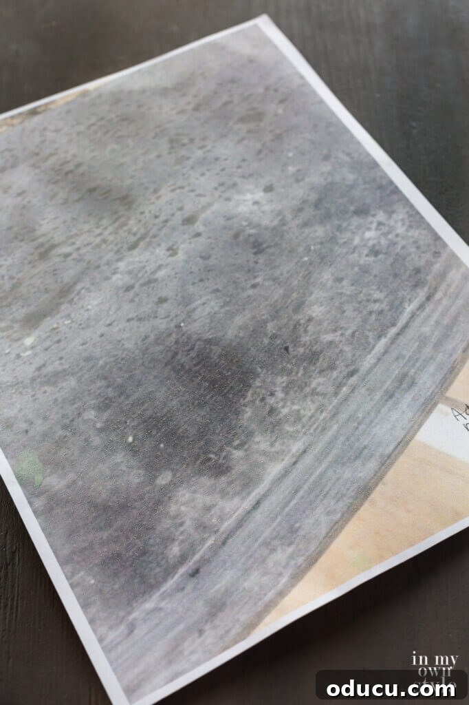 Zinc Effect Wooden Table Surfaces 5 A close-up inspiration photo from Pinterest showing a textured surface designed to look like aged, weathered zinc, featuring characteristic grey tones and subtle pitting, serving as a guide for the faux painting project.