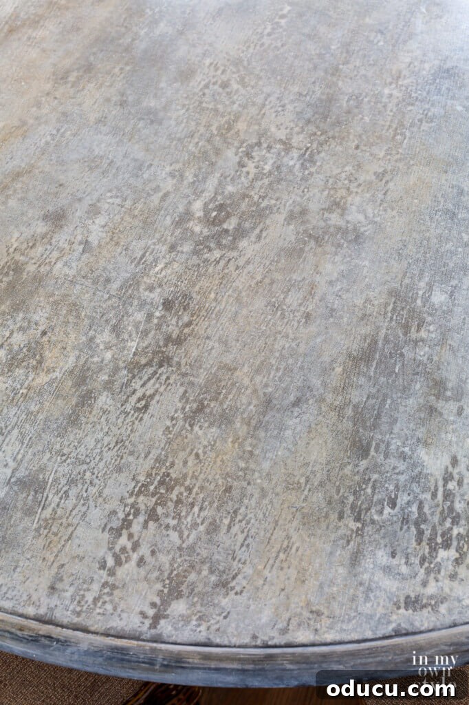 Zinc Effect Wooden Table Surfaces 7 A detailed close-up shot of the faux zinc finish on the table, revealing the intricate textures and color variations that contribute to its realistic aged metal appearance, capturing the essence of a distressed surface.