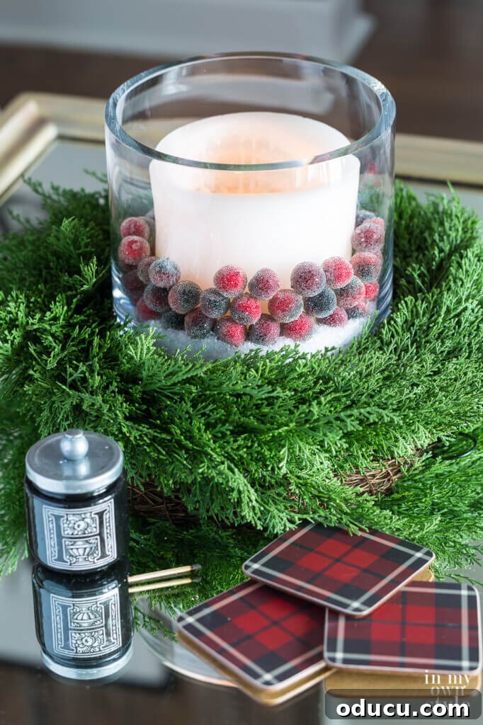 Effortless Festive Home Styling 11 A serene Christmas coffee table vignette featuring a white candle nestled among faux sugared cranberries and a cedar wreath, evoking a rustic and festive ambiance.