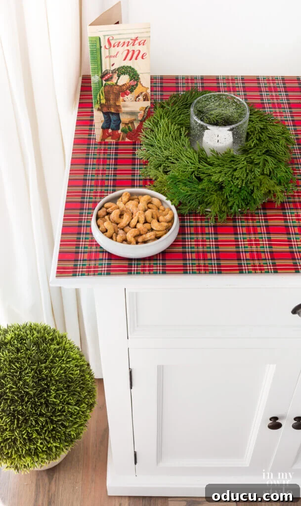 Effortless Festive Home Styling 16 A sideboard elegantly covered with plaid gift wrap, offering an affordable and creative Christmas decorating idea that transforms everyday surfaces into festive displays.