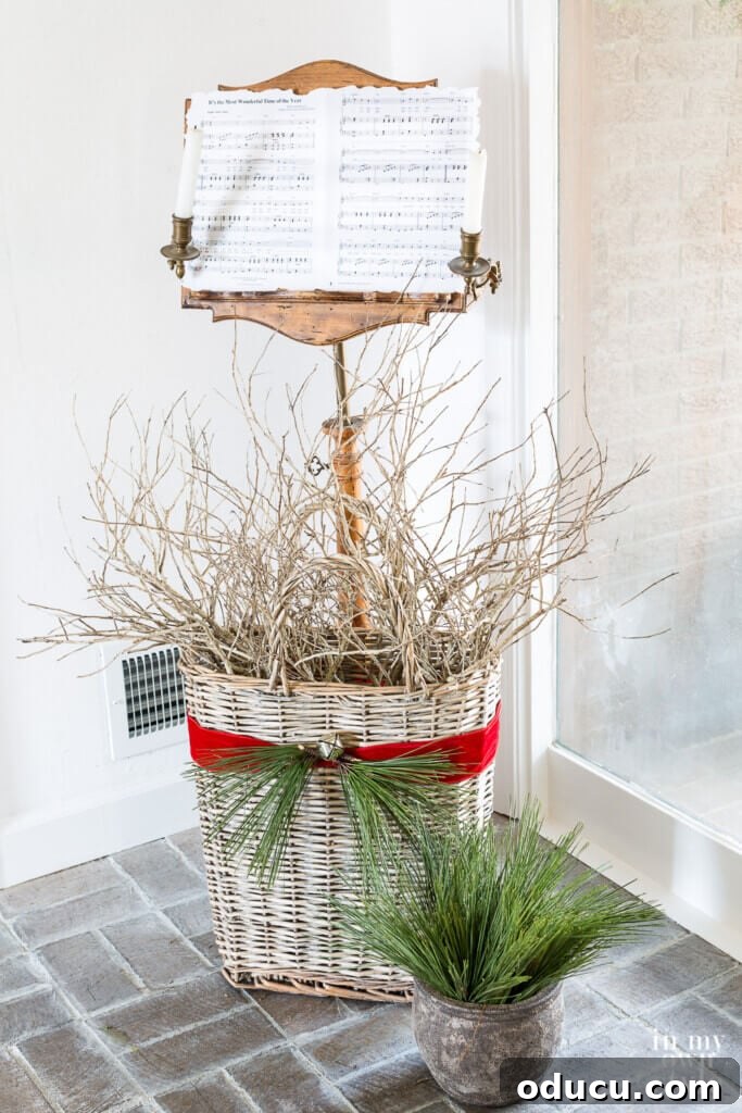 Effortless Festive Home Styling 8 An antique music stand, beautifully decorated for Christmas with a vintage sheet music displaying 'It's The Most Wonderful Time of the Year', stands beside a basket of festive branches.