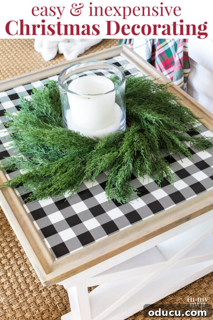 Cozy & Chic Christmas Coffee Table on a Budget 6 Beautifully decorated farmhouse coffee table for Christmas featuring black and white checked gift wrap, a cedar wreath, and a candle. Text overlay highlights 'easy and inexpensive Christmas decorating.'