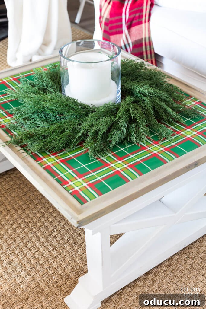 Cozy & Chic Christmas Coffee Table on a Budget 4 Coffee table elegantly covered with green plaid gift wrap, adorned with a festive wreath and a glowing candle