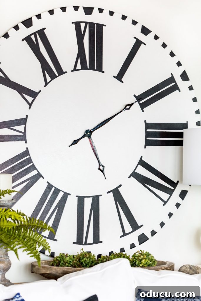 Curated Styles 21 2 An oversized white clock with bold black Roman numerals and distressed details, adding a rustic yet elegant touch to a living space. Perfect for fall and winter decor.