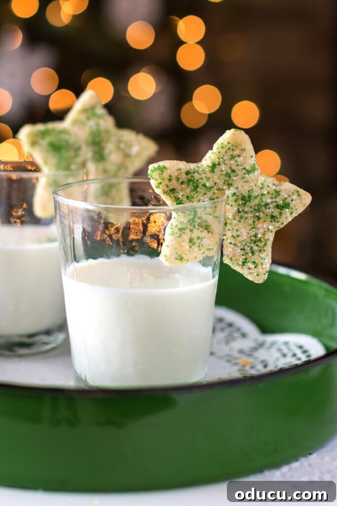 2 star Christmas cookies on the rims of glasses of milk.