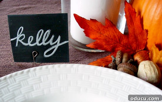 Effortless Thanksgiving Place Card Ideas for a Memorable Table 5 DIY place card holder made ingeniously from a bent paper clip, holding a simple black cardstock name tag.