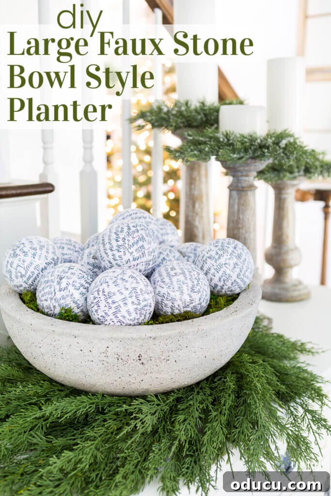 Large faux cement bowl elegantly placed on a wreath on a sideboard, with text overlay: 'DIY Large Faux Stone Bowl Style Planter.'