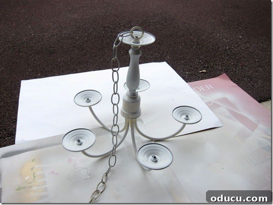 Detailed tutorial on how to spray paint a brass chandelier for outdoor use, mimicking a high-end look.