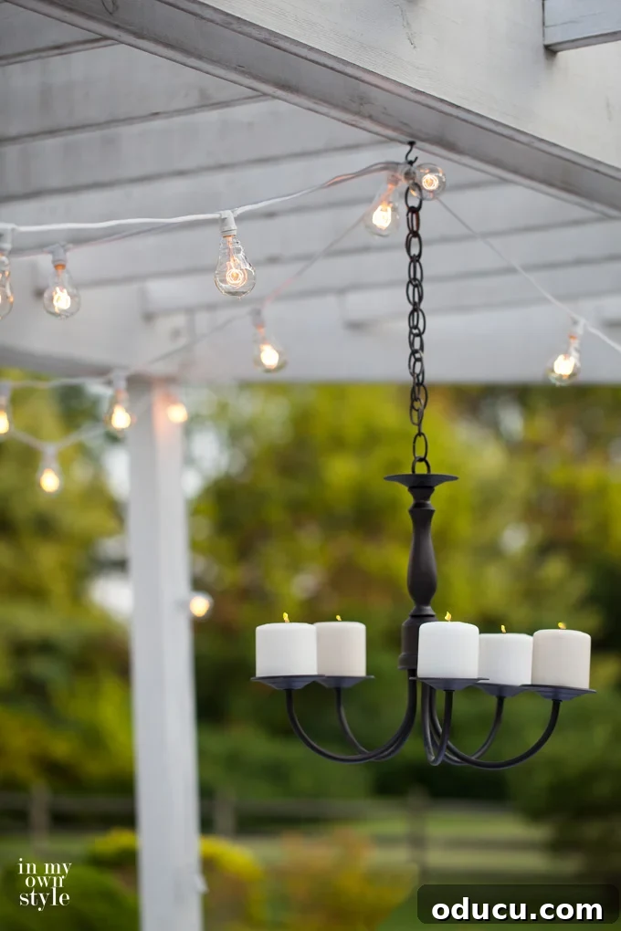 Patio table adorned with pink flowers, demonstrating the elegant placement of the newly transformed outdoor candle chandelier.