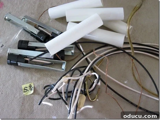 Pile of electrical components removed from a chandelier, illustrating the transformation process for an outdoor light.