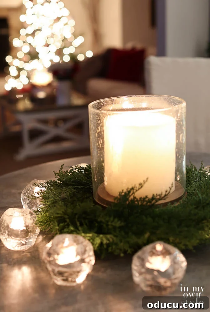 Candle on table with Christmas tree in the background