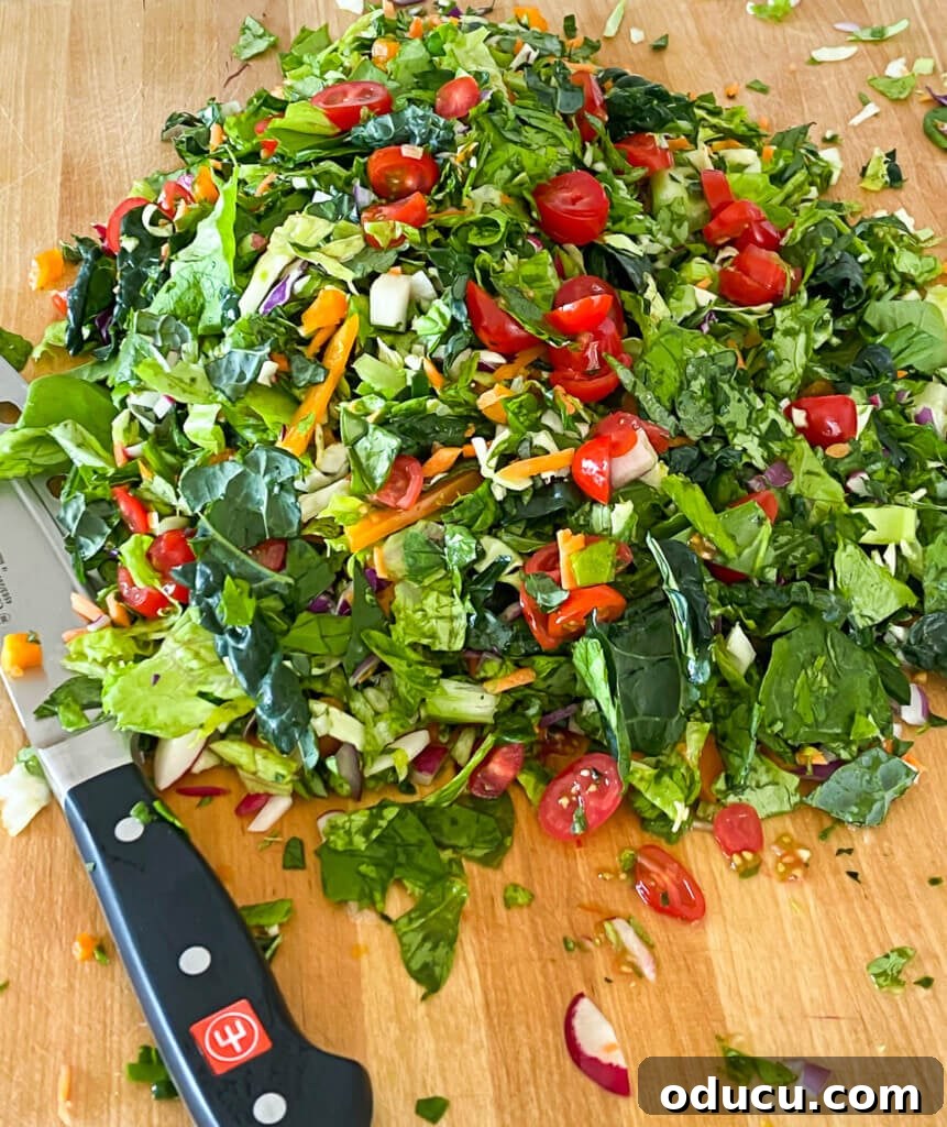 My Personal Weight Loss Victory 12 Cut up lettuce . leafy greens and vegetables on a wood cutting board. Chef's knife on the side.
