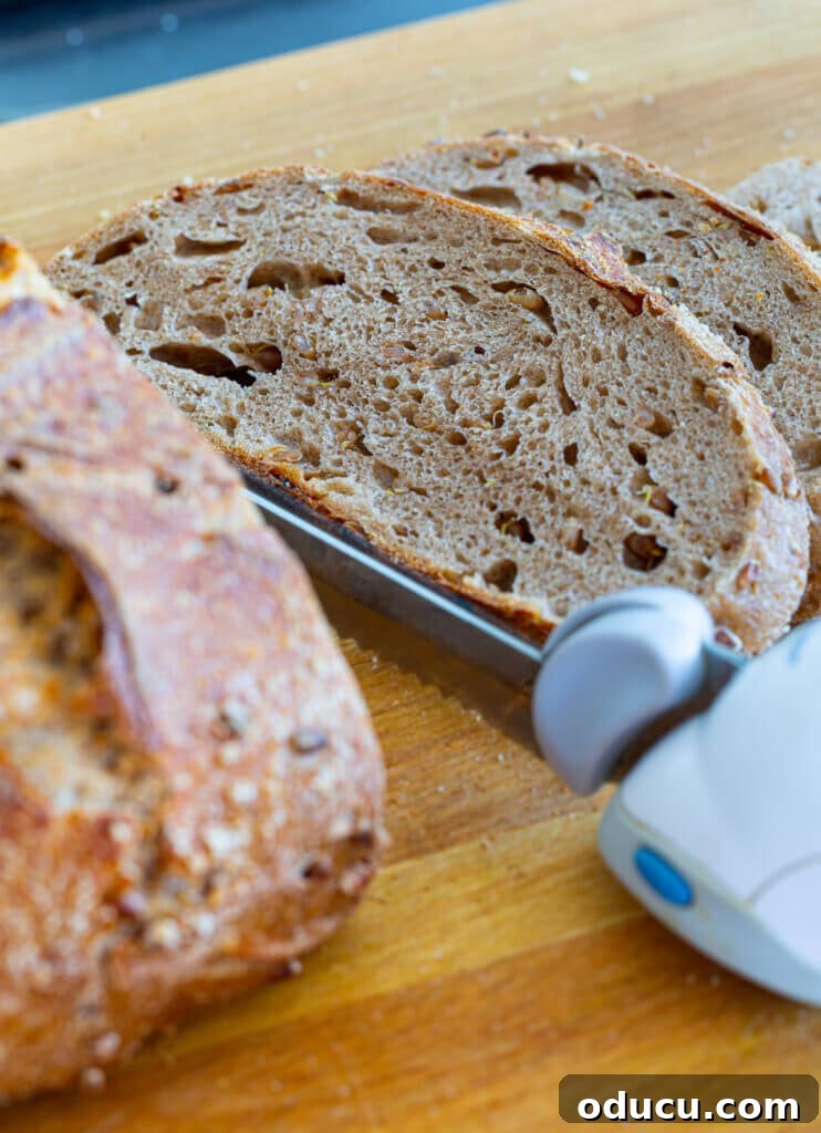 My Personal Weight Loss Victory 13 Sourdough bread being cut on a wood cutting board. Yes bread can be part of a plant-based weight loss success story.