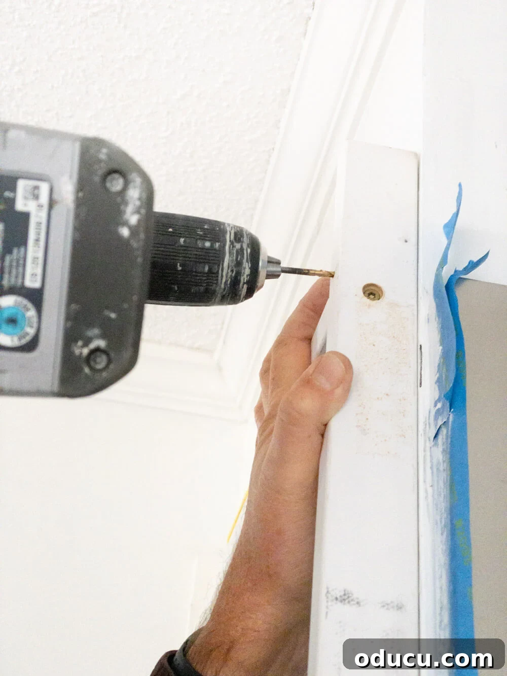 DIY Floor-to-Ceiling Wall Plate Rack 13 Demonstration of attaching a plate rack frame to a wall using wood screws.