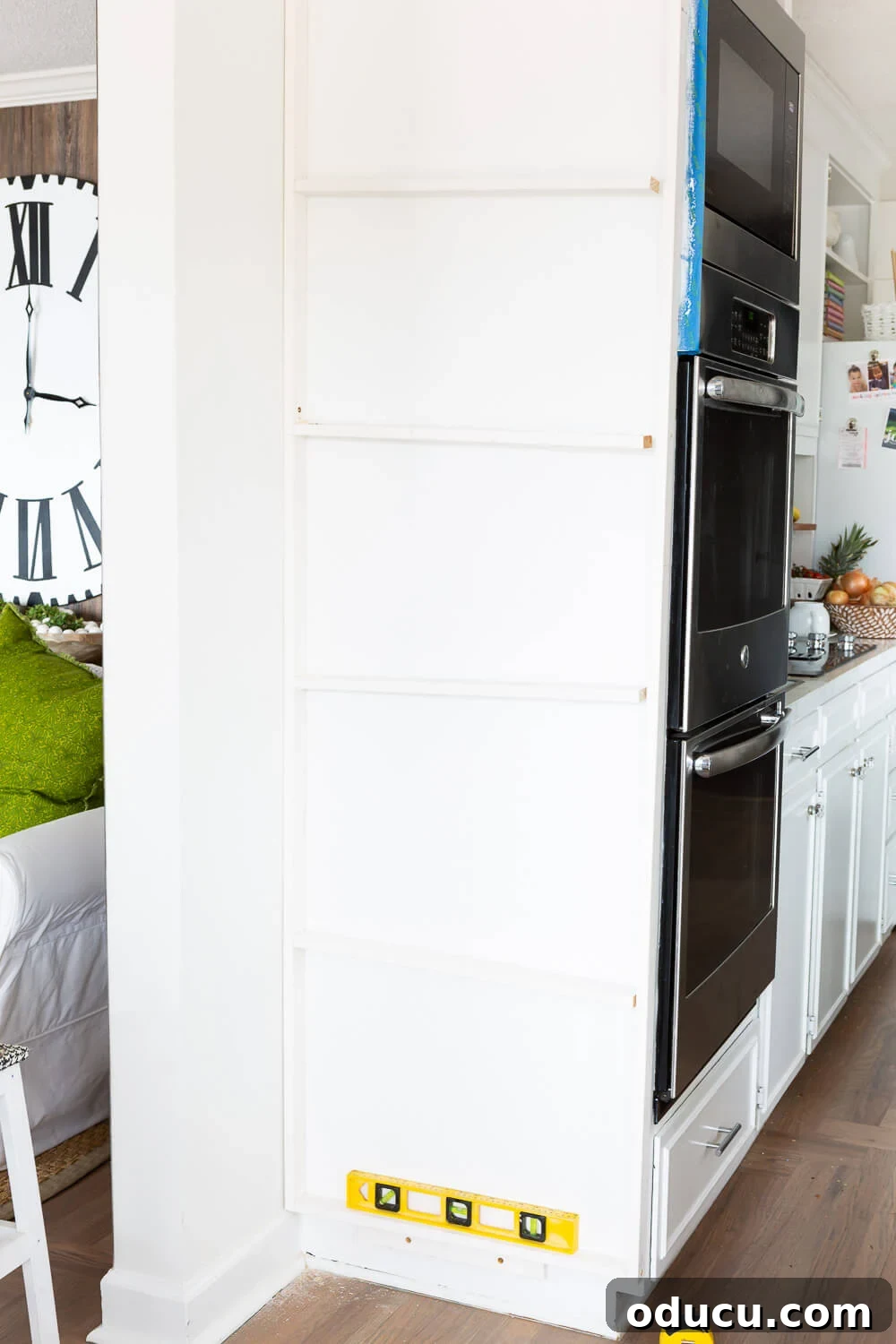 DIY Floor-to-Ceiling Wall Plate Rack 14 Using a level to ensure precise shelf placement during plate rack construction.