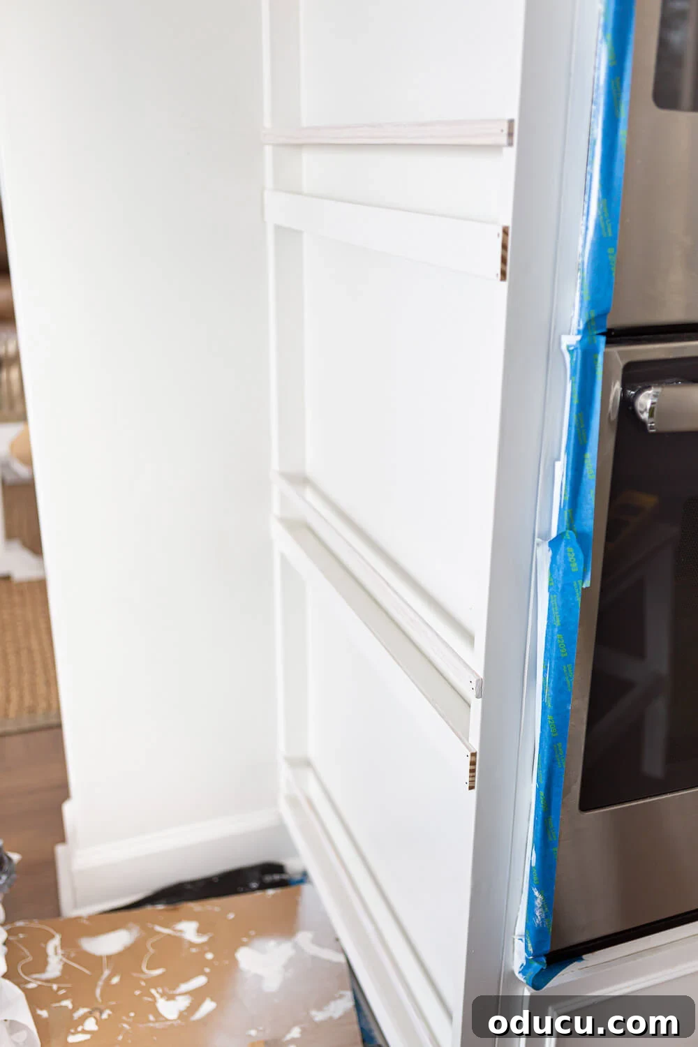 DIY Floor-to-Ceiling Wall Plate Rack 16 Cutting wood strips for plate guard rails on a kitchen plate rack.
