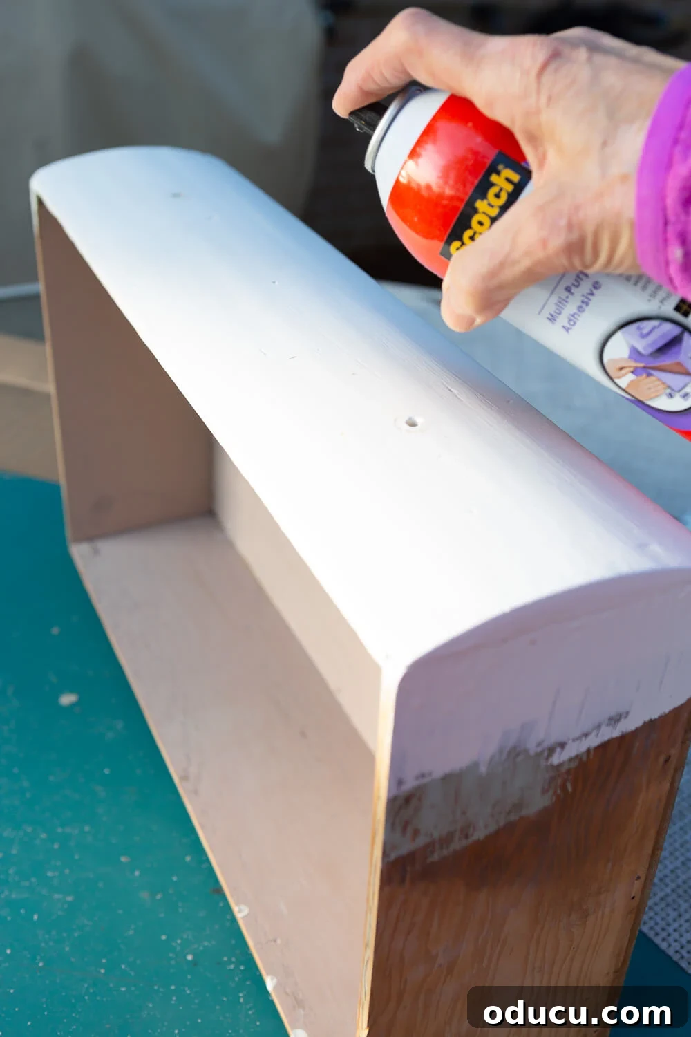 Textured Drawer Bedside Table Revamp 10 applying spray adhesive to the front of a drawer for a woven front furniture makeover