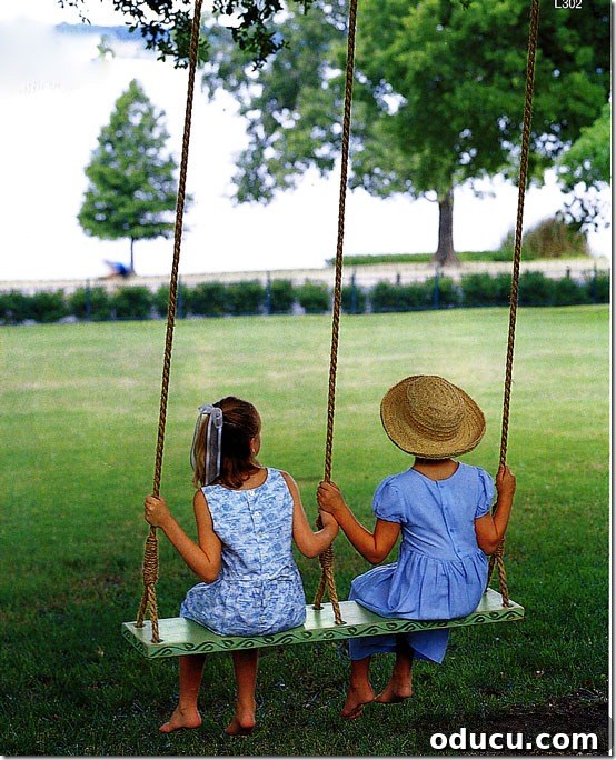 Uncover Your Personal Decorating Style 15 Two girls on a double swing hung from a tree, symbolizing simple pleasures and outdoor enjoyment.