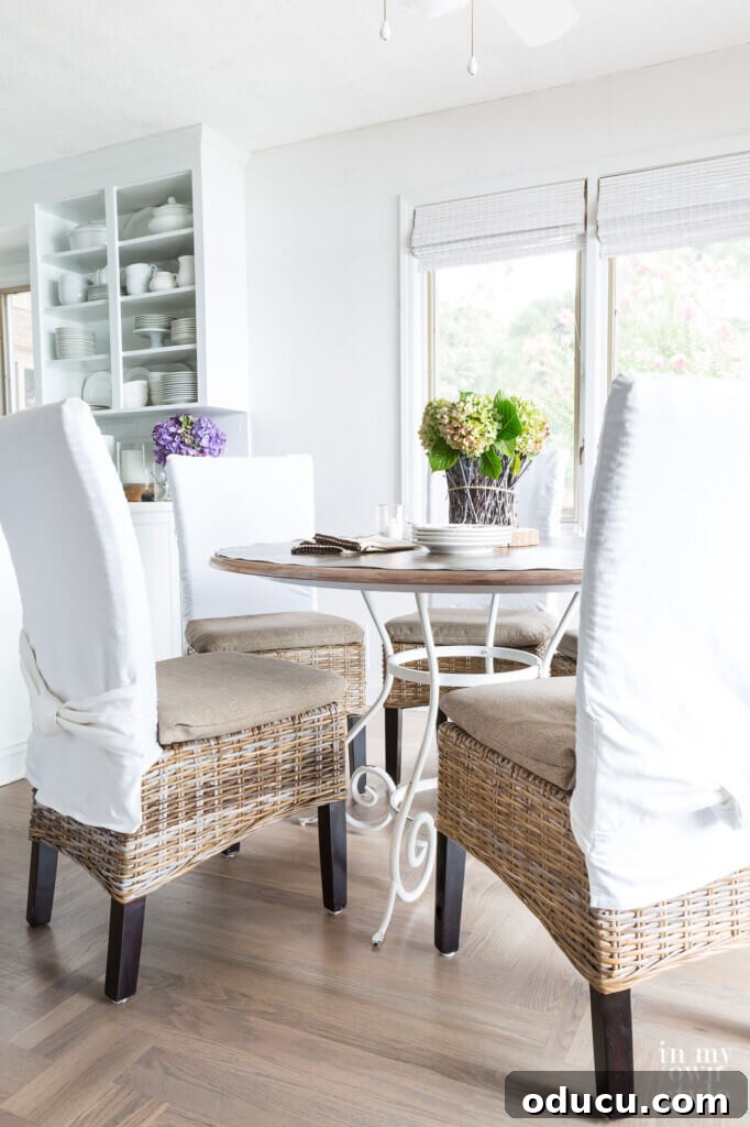Uncover Your Personal Decorating Style 7 Kitchen dining area with new neutral cushion covers on chairs, crafted from repurposed fabric, enhancing light and view.