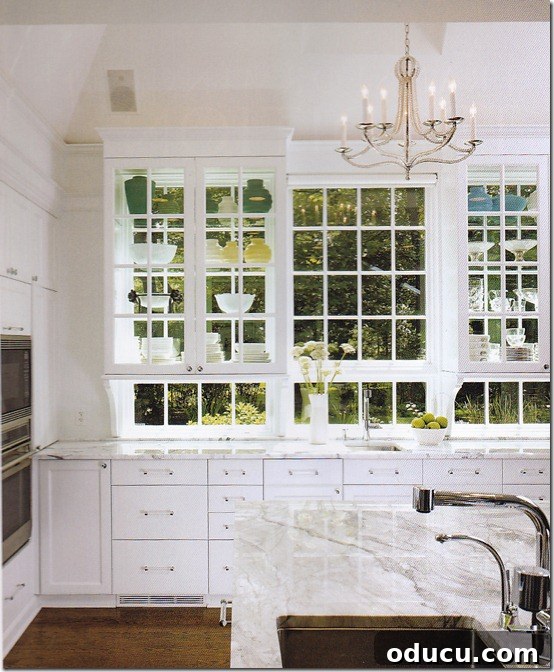 Uncover Your Personal Decorating Style 8 A bright kitchen window wall featuring white counters and cabinets, maximizing natural light.