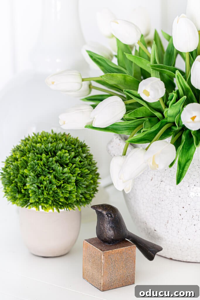 Blossom Your Entryway This Spring 3 Close-up of spring entryway decor featuring a textured vase and a small bronze bird.