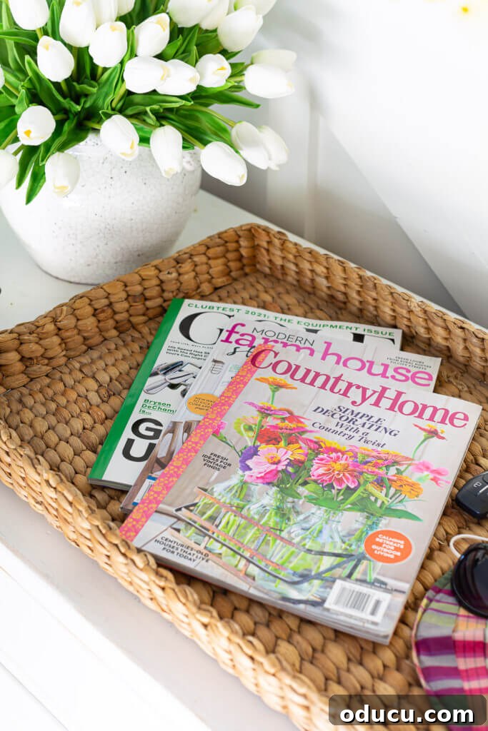 Blossom Your Entryway This Spring 6 Low-sided woven basket holding three decorating magazines, placed on a console table.