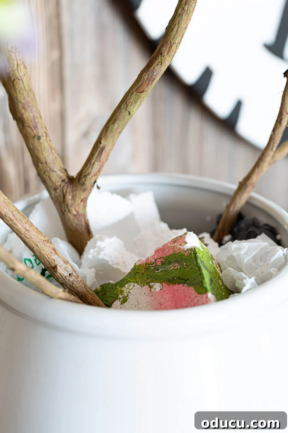 Styrofoam stuffed in planter to hold branches in place.
