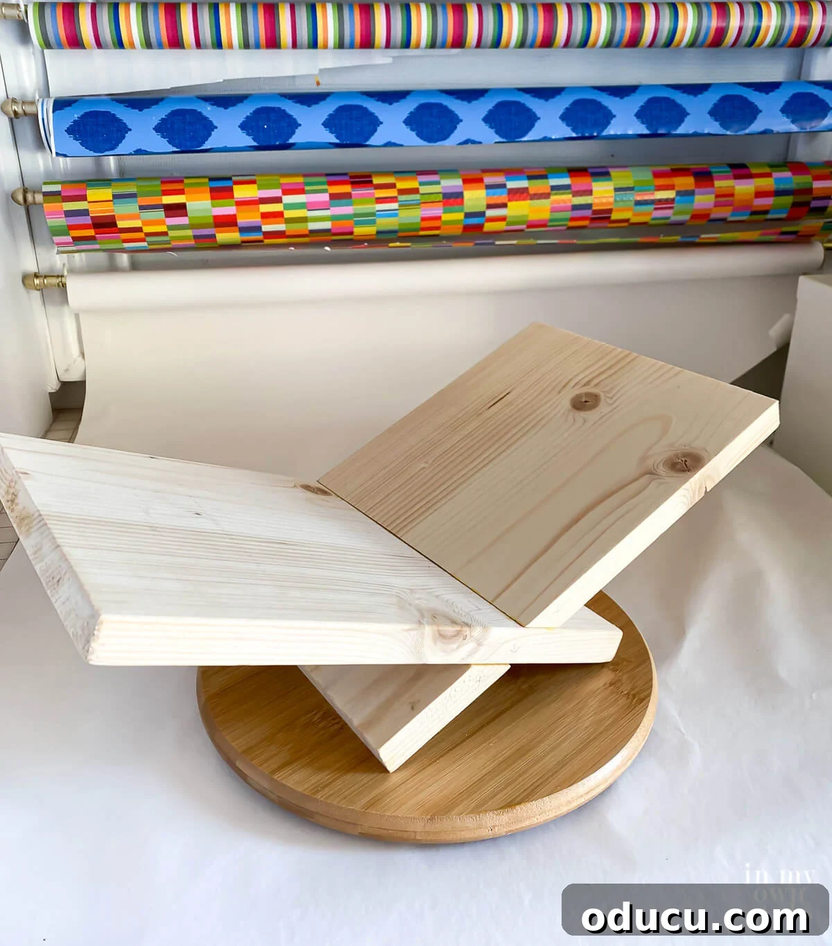 Unfinished x shaped book holder on top of wood turntable.