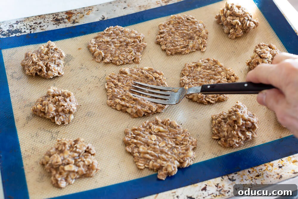 Faux Crab, Real Taste: Vegan Mini Cakes Recipe & Smart Plant-Based Eating Hacks 4 Flattening banana oatmeal cookies on baking sheet with a fork