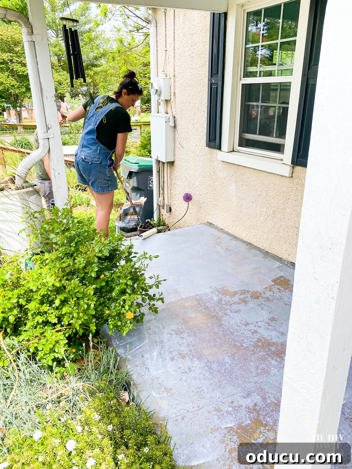 Transform Your Concrete Porch or Patio with Paint and Stencils 7 Rolling on concrete primer on porch floor.