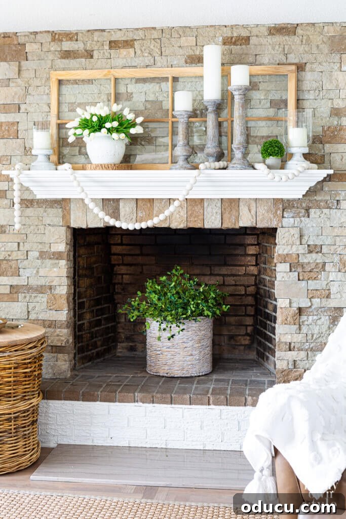 Inspiring farmhouse decorating ideas for summer, featuring a stone fireplace mantel adorned with neutral colors and vibrant greenery accents.