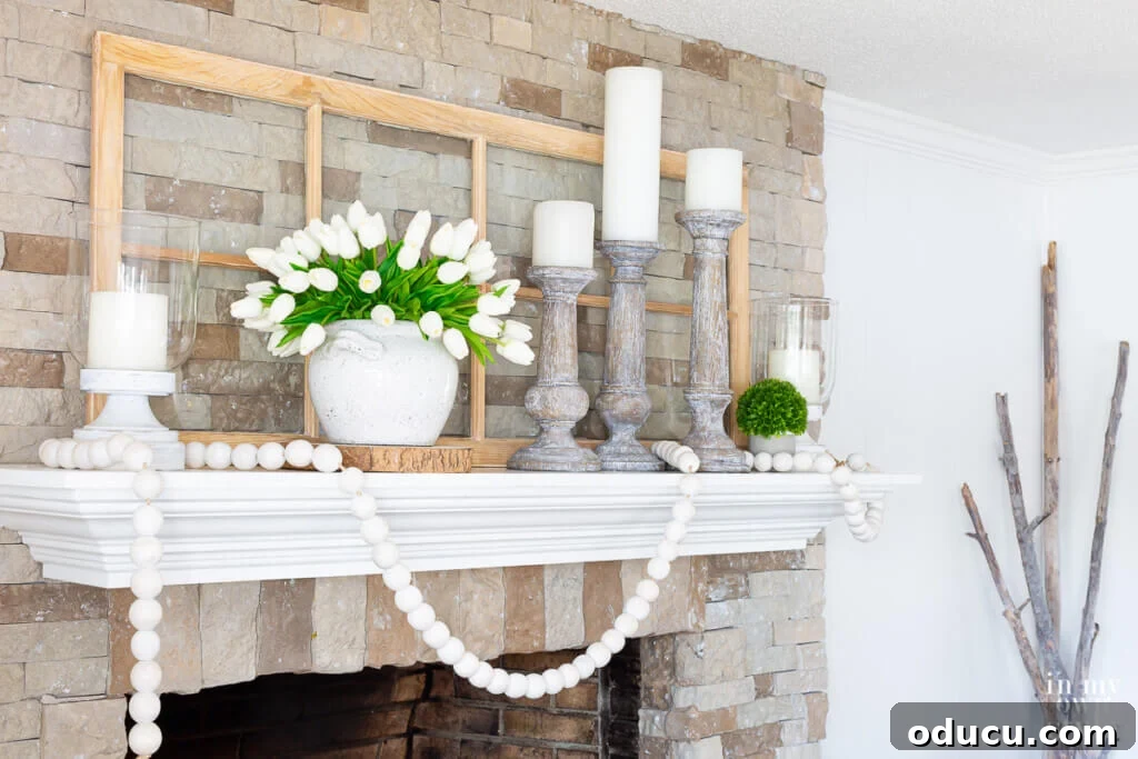 Wide shot of the stone fireplace adorned with white and green summer themed mantel decor, embodying a refreshing farmhouse aesthetic.