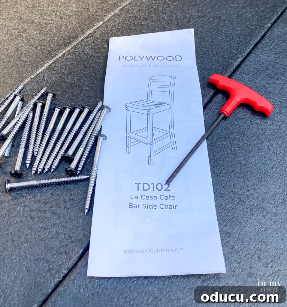 Transforming My Deck with POLYWOOD Outdoor Furniture 13 A close-up of a POLYWOOD La Casa Cafe Bar Side Chair instruction pamphlet, alongside screws and a manual screwdriver, illustrating simple assembly.