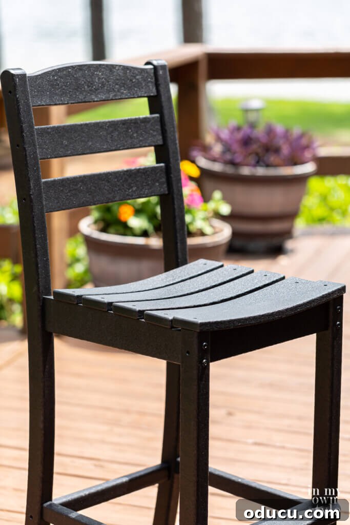 Transforming My Deck with POLYWOOD Outdoor Furniture 7 A close-up view of a comfortable black POLYWOOD La Casa Cafe Farmhouse Trestle Bar Set chair, highlighting its ergonomic design and sturdy construction.