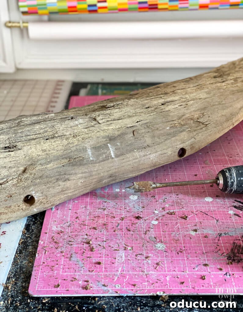 Craft a Natural Driftwood Art Display 13 Drilling holes into the driftwood piece with a power drill, preparing it for mounting on the sculpture stand.