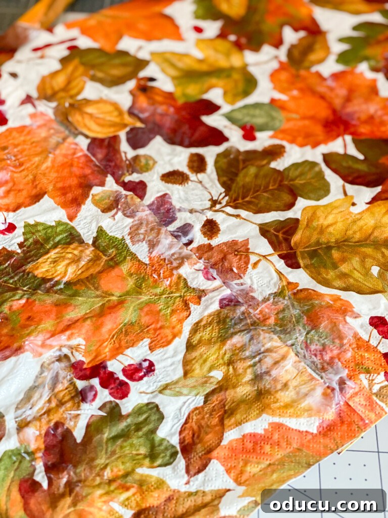 Crafting Versatile Serving Trays for Every Occasion 17 Detailed image showing how to join two paper napkins seamlessly when creating a decorative serving tray insert, using Mod Podge to blend the edges.