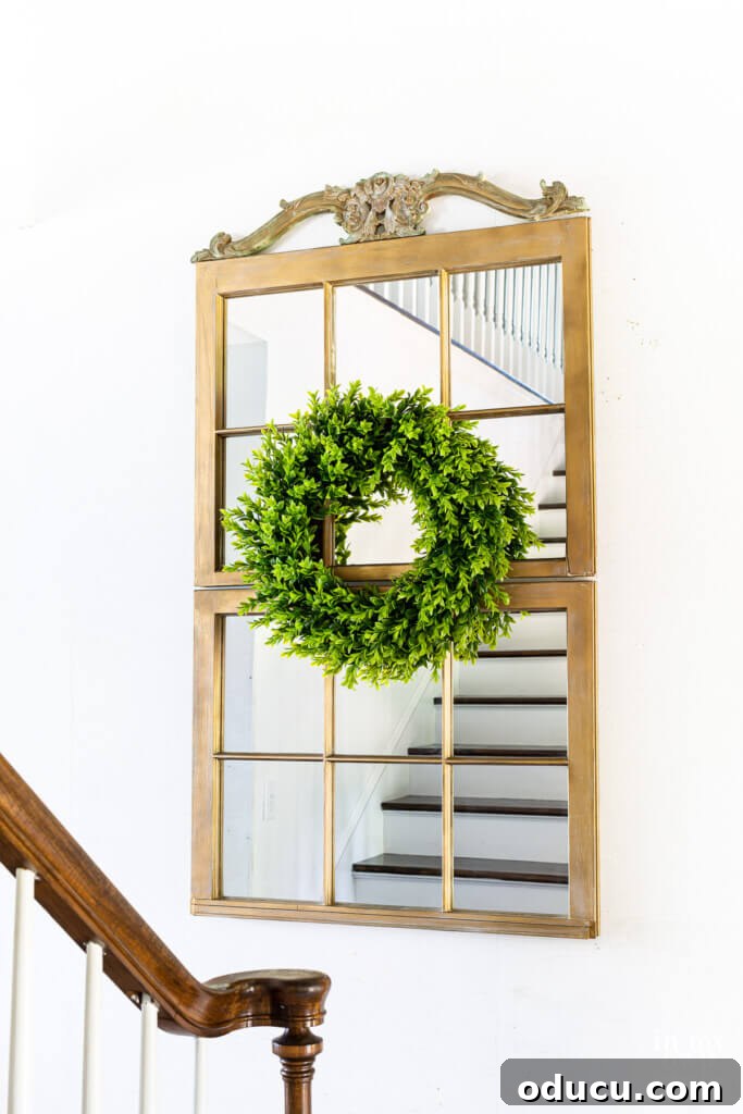 Two old wood window frames repurposed and placed on a wall to create a large decorative mirror, enhancing home entryways.