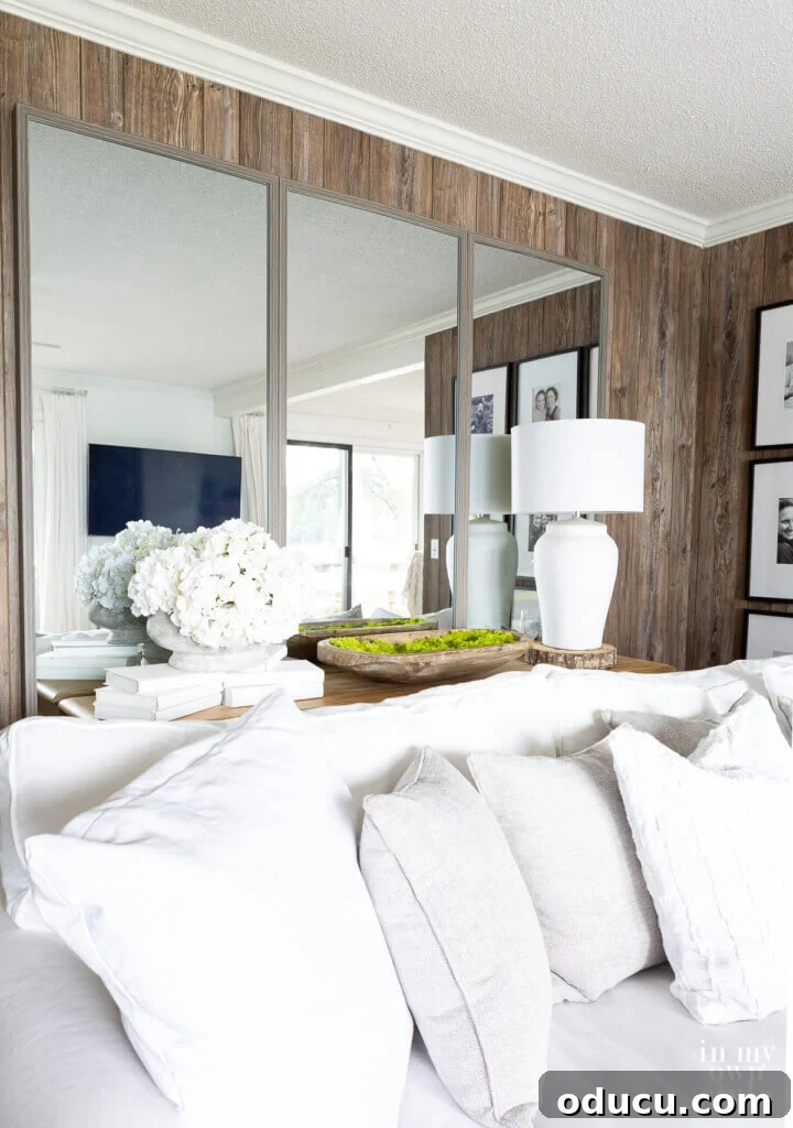Grand Living Room on a Small Budget: $240 Makeover 6 Large floor mirrors cleverly hung on a living room wall, creating an illusion of expanded space and brightness.