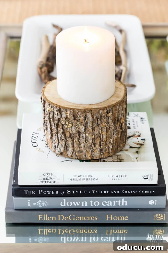 Books and candle on cut round a tree trunk on a coffee table.