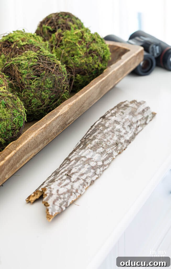 Decorating with nature for fall. Piece of bark and long dough bowl filled with moss spheres.