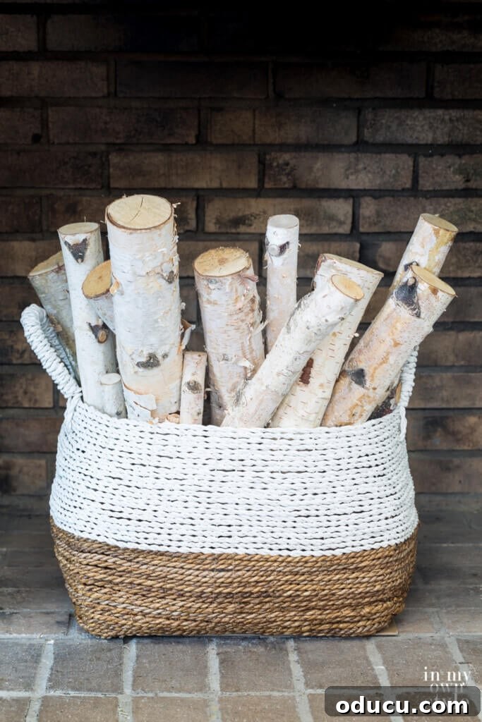 Bundle of Birch logs in a large basket in a fireplace.
