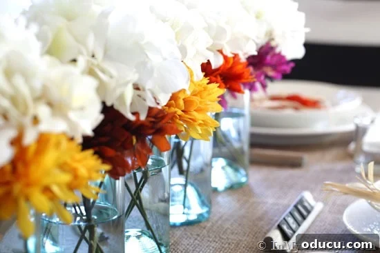 Cozy Autumn Vases: Effortless Ideas for a Warm Home 8 Mason jars lined up in the center of a dining table are used a fall flower vases.