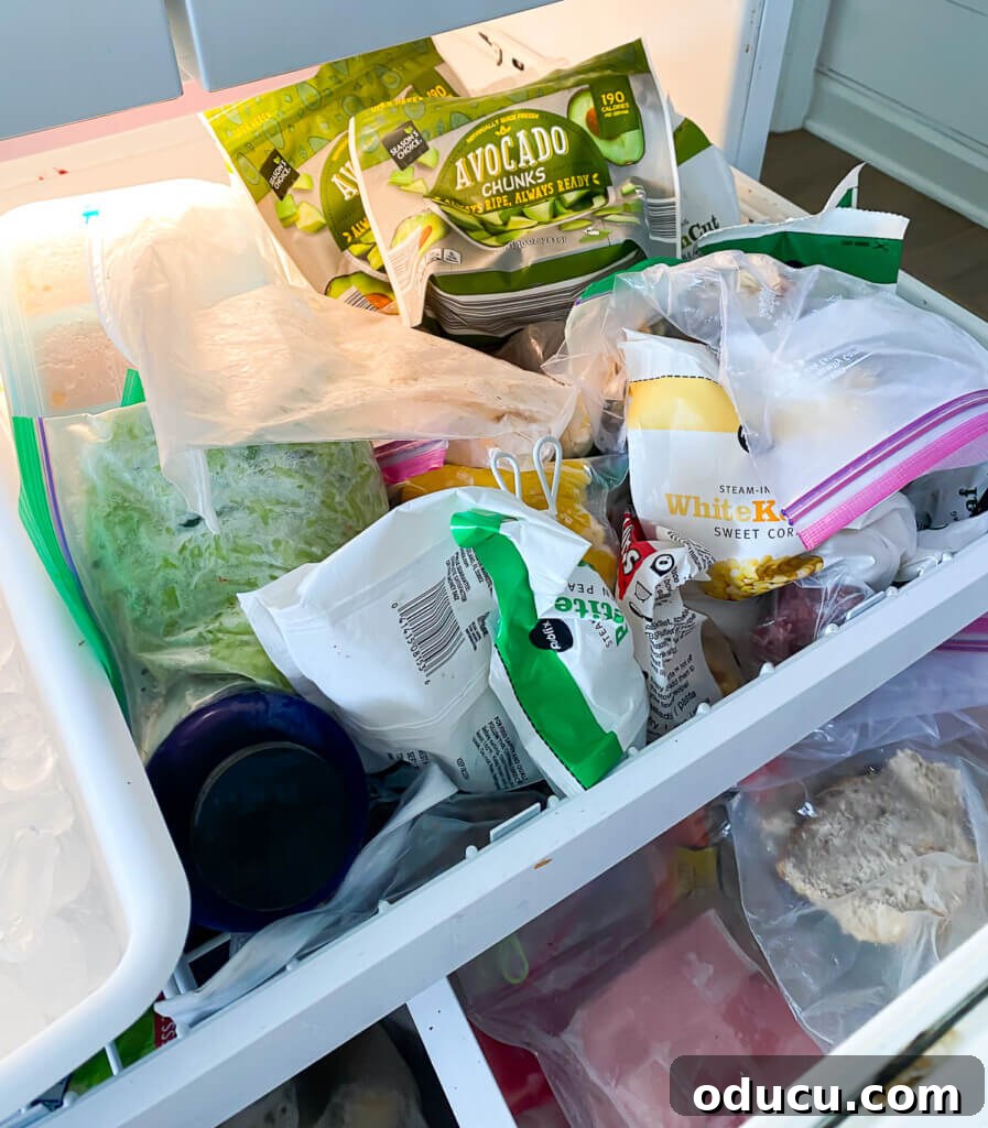 DIY Freezer Drawer Organization Hacks 2 Top slide out drawer on refrigerator with bottom freezer image showing the contents are a mess. Before image.