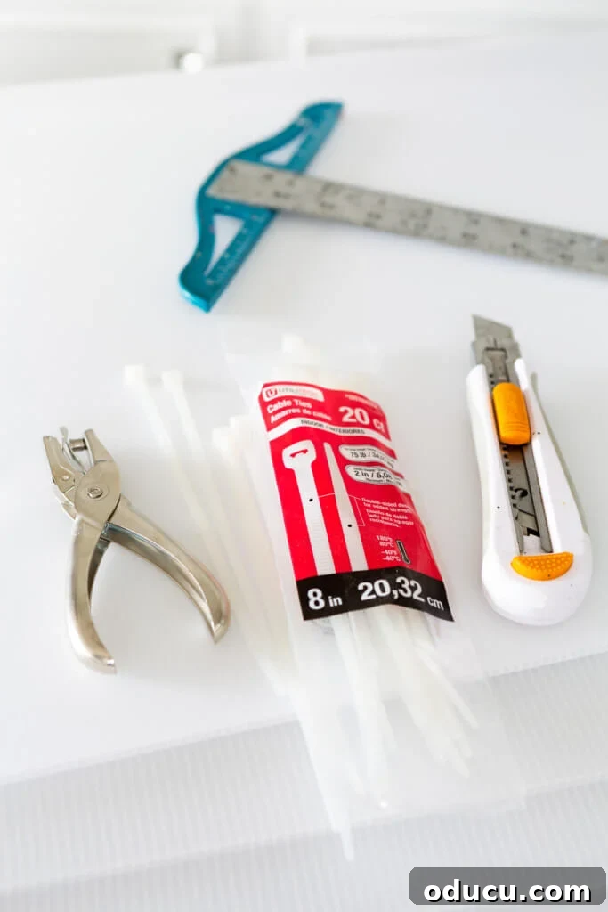DIY Freezer Drawer Organization Hacks 6 a paper hole punch, zip ties, craft knife and t-square on a table.