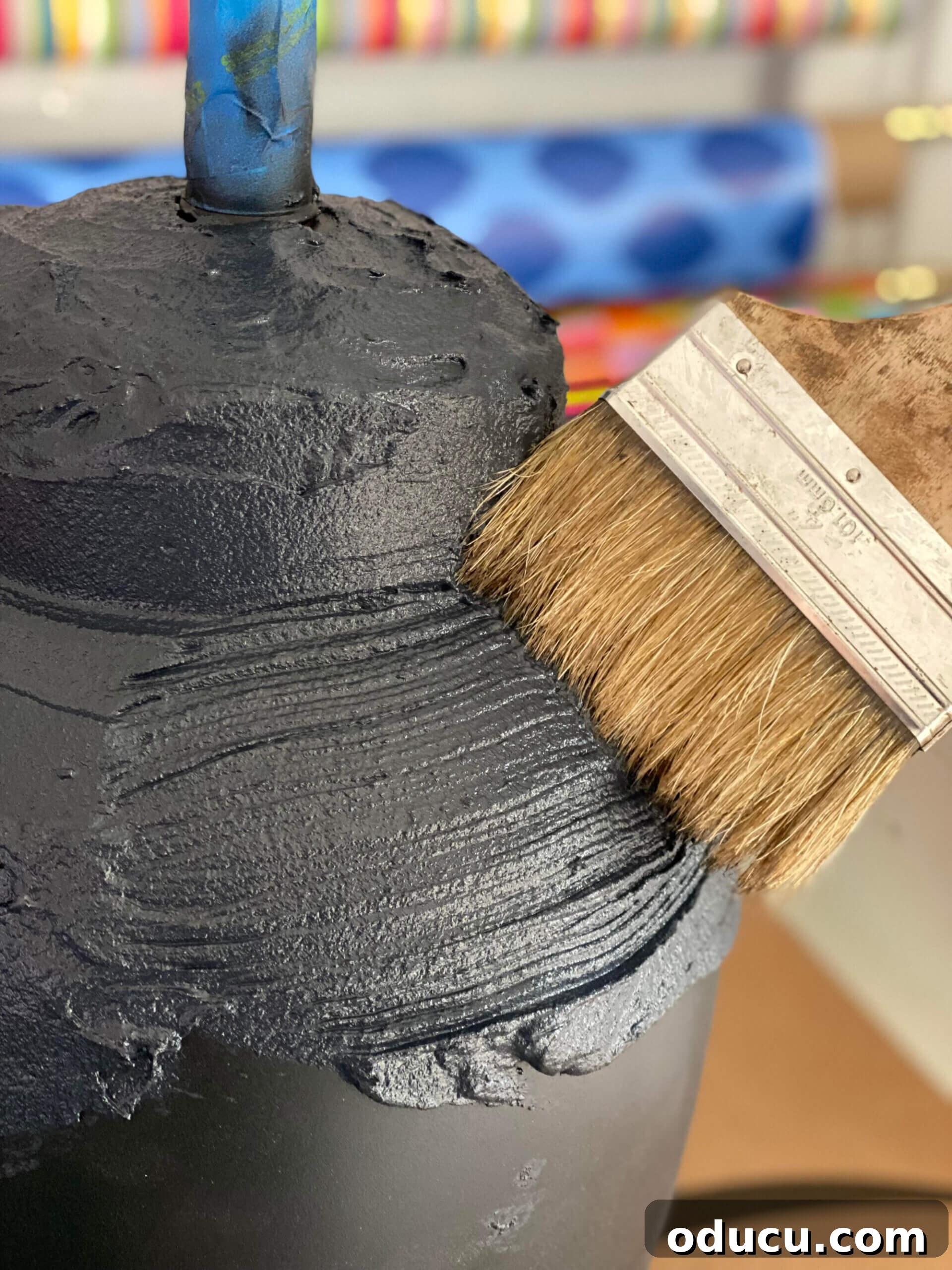 Craft Stunning Table Lamps for Less 9 brushing on concrete patch mixed with black paint to a lamp base.