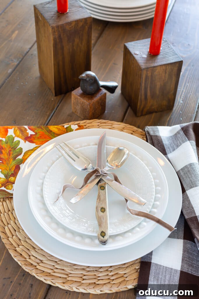 Transform Wood Scraps Into Beautiful Candle Holders Easily 4 Table place setting of a white dinner plate layered with a fork, knife and spoon tied with brown ribbon.