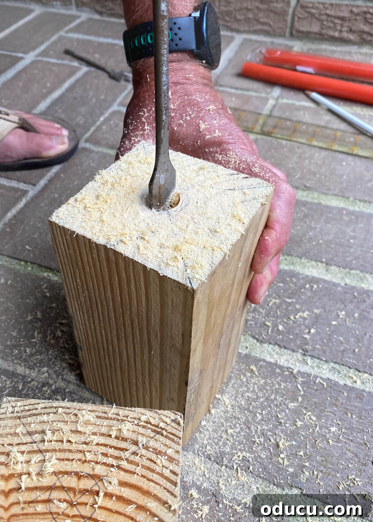 drilling hole in cut 4 x 4 post scrap of wood.