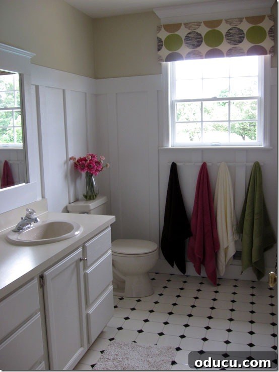 Bathroom Floor After Renovation Transformed bathroom with board and batten, tan walls, and updated flooring for a spa-like ambiance.