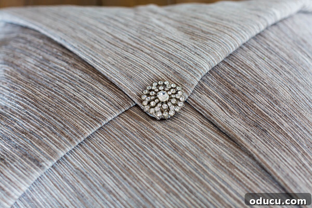 Rhinestone pin that secures a decorative throw pillow on a pillow.